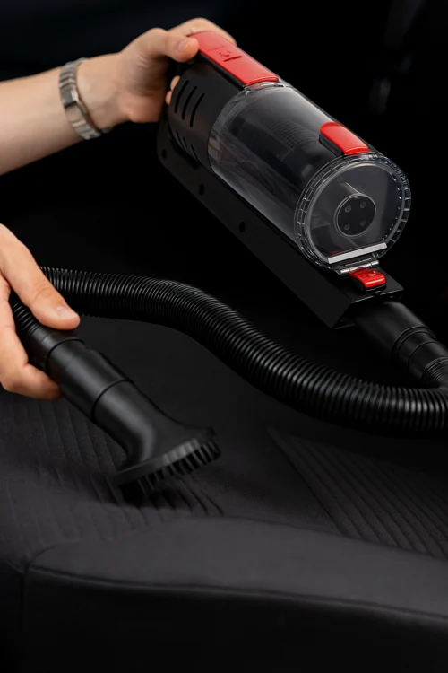 Автопилосос VOIN V80 у процесі очищення сидіння автомобіля з використанням щітки та гнучкого шланга